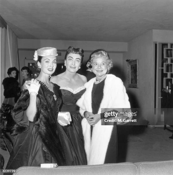 American actor Ann Blyth, American actor Joan Crawford and Norwegian figure skater and actor Sonja Henie pose together at a Hollywood event,...
