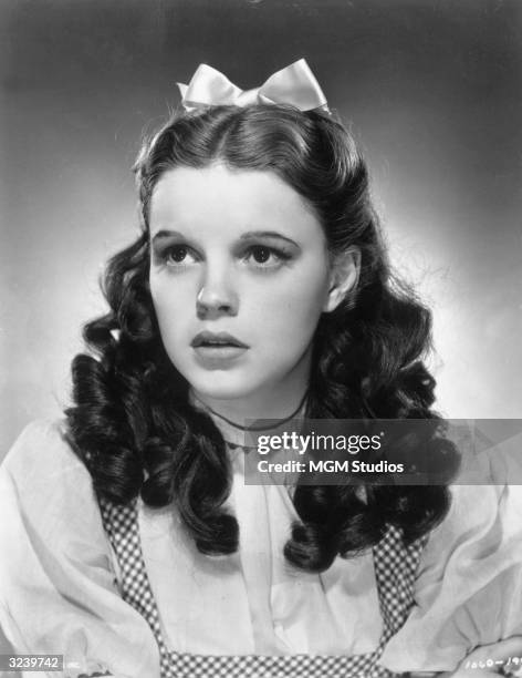 Promotional studio portrait of American actor and singer Judy Garland wearing her costume as Dorothy from director Victor Fleming's film, 'The Wizard...