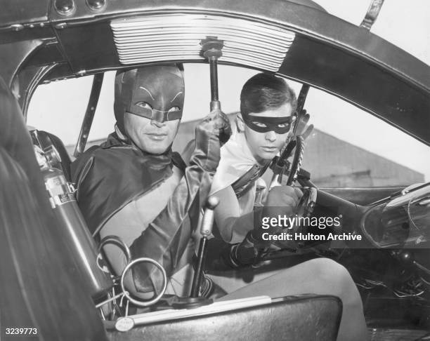Actors Adam West and Burt Ward as Batman and Robin in the Batmobile in a still from the television series, 'Batman'.