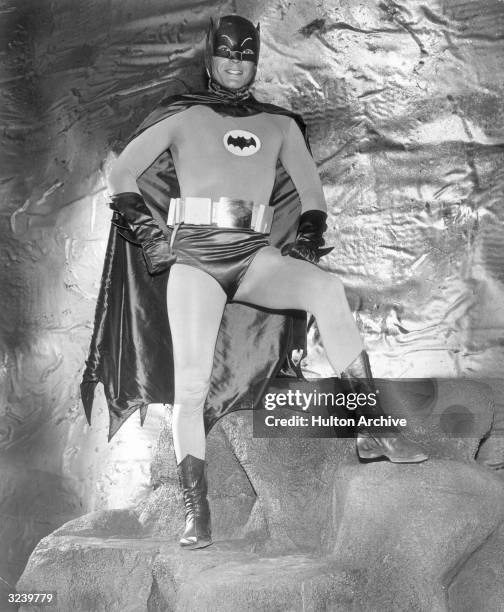 Actor Adam West wears his Batman costume in the Batcave in a full-length promotional portrait for the television series, 'Batman'.