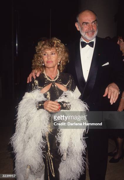 Scottish-born actor Sean Connery walks with his arm around his wife, French-Moroccan painter Micheline Roquebrune, as they attend a formal event, Los...