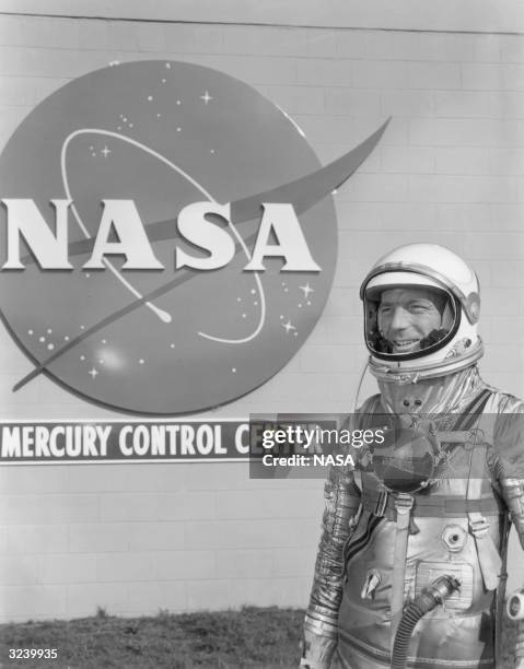 American astronaut M Scott Carpenter stands in front of the NASA Mercury Control Center, wearing a spacesuit, Cape Canaveral, Florida.