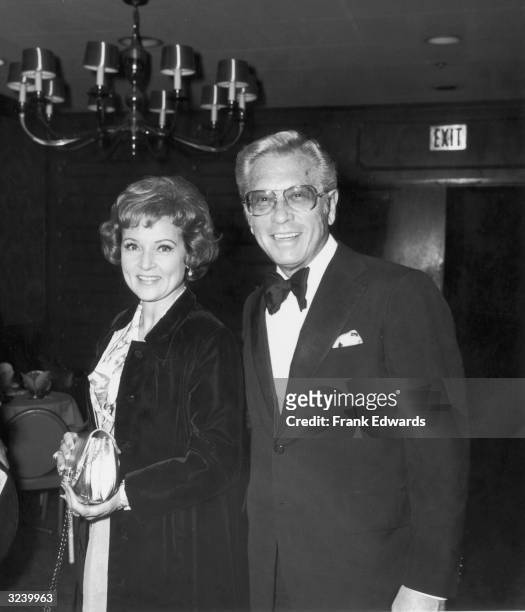 American actor Betty White stands smiling with her husband, TV producer and host Allen Ludden , wearing a tuxedo, at an International Broadcasting...