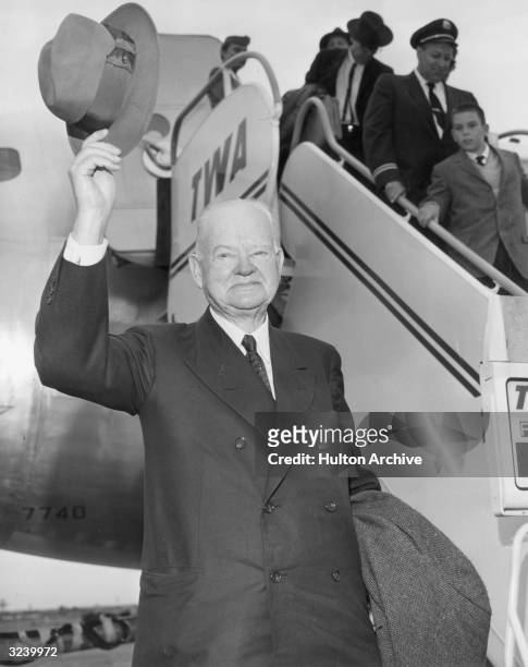 Former American president Herbert Hoover tips his hat after his return from a vacation in San Francisco, New York International Airport, New York...