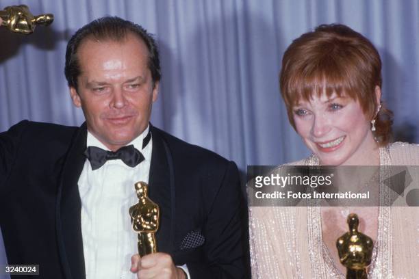 American actors Jack Nicholson and Shirley MacLaine pose together in front of a blue curtain, holding their Oscars for director James L Brooks' film,...