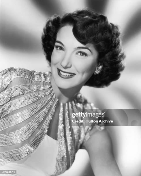 Portrait of American actor Julie Adams smiling in a sequined dress in a promotional portrait for the film, 'Finders Keepers'.