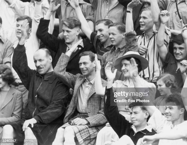 King George VI and Queen Elizabeth joining in with a song during a visit to the King's Camp at Abergeldie Castle near Balmoral. Princess Margaret...