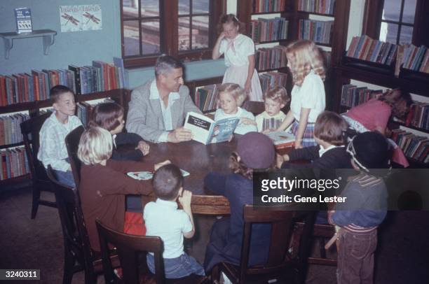 American author and illustrator Dr. Seuss reading his book, 'The Cat in the Hat', to a circle of children at a public library in La Jolla,...