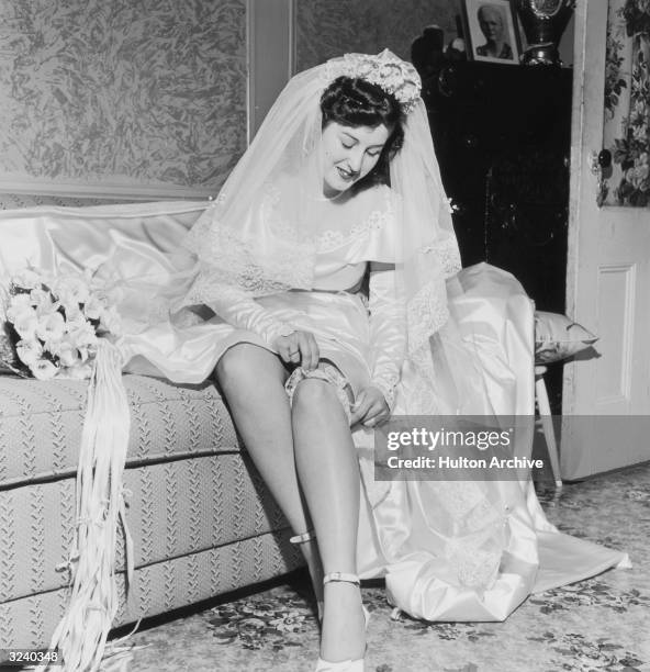 Bride pulls on her garter before her wedding ceremony.