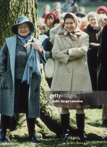 Queen Elizabeth II and Elizabeth the Queen Mother , looking relaxed in warm outdoor clothes while watching the Badminton Horse Trials.