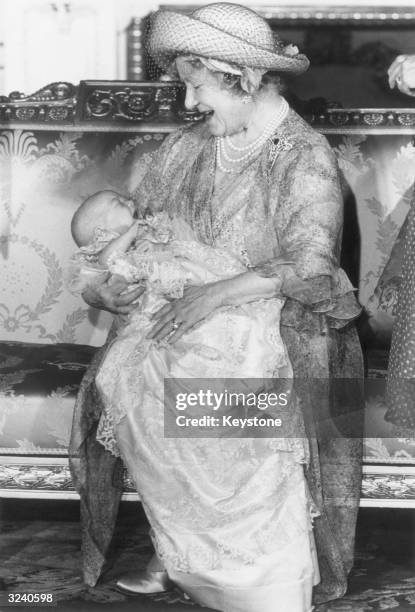 Queen Elizabeth, The Queen Mother , holding baby Prince William after his baptism at Buckingham Palace. He is wearing the Royal Christening Robe.
