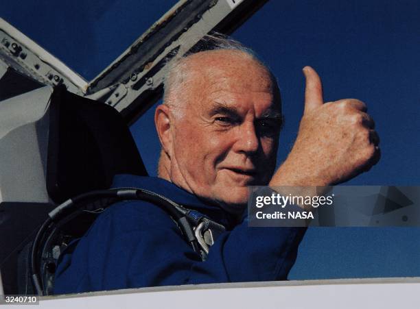 American astronaut John Glenn gives a thumbs up signal from the cockpit of an aircraft, three days before embarking on the STS-95 mission on the...