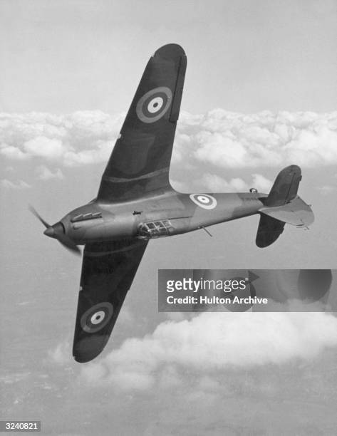 The pilot of a British RAF Hawker Hurricane Mk1 turns his plane upside down above the clouds, World War II.
