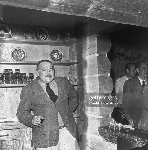 American writer Ernest Hemingway holds a cordial at a party for actor Gary Cooper at Trail Creek Cabin in Ketchum, Idaho.