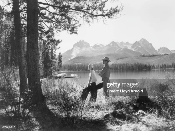 American actor Gary Cooper and his wife 'Rocky' (actor Sandra Shaw , pose beside the Red Fish Lake in Idaho.