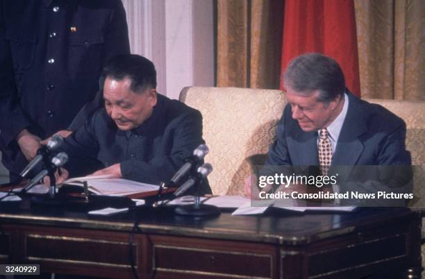 American president Jimmy Carter and Chinese Communist leader Deng Xiaoping sign papers to establish formal diplomatic ties between the US and China...