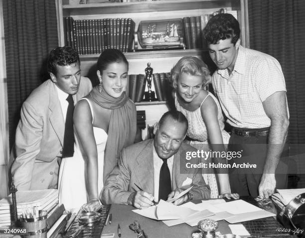 American film producer Hal Wallis signing the contracts of four young actors at the Paramount Studios lot, Hollywood, California. L-R: Richard...