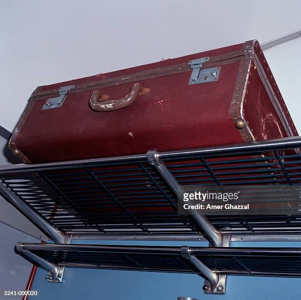 suitcase on luggage rack - amer ghazzal fotografías e imágenes de stock