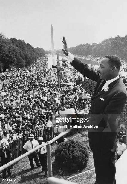 American minister and civil rights leader Dr Martin Luther King Jr waves to the crowd of more than 200,000 people gathered on the Mall after...