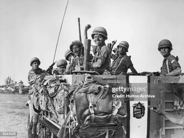 Israeli soldiers smile and raise their hands from the bed of a large army truck during the Six Day War, Abu Agillah in the Gaza strip, Middle East....