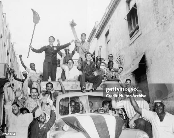 Truck filled with Cuban men rides through a narrow Havana street after the triumph of the Cuban Revolution and the overthrow of former dictator...