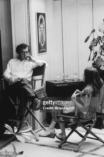 American actor and director Woody Allen sits in his director's chair and talks to actress Shelley Duvall on the set of his film, 'Annie Hall'.