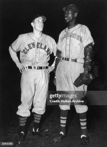 American baseball pitchers Bob Feller of Cleveland Indians , and Leroy 'Satchel' Paige of Kansas City Monarchs, standing together after their teams...