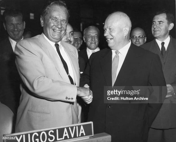 Yugoslav President Josip Broz Tito , smiling and shaking hands with Soviet Premier Nikita Khrushchev in the assembly hall of the United Nations...