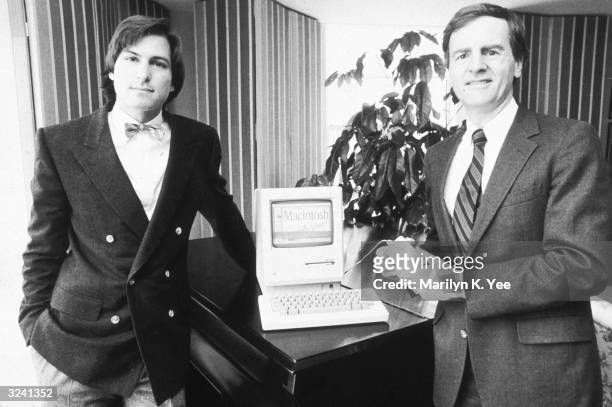 American businessman Steve Jobs , Chairman of Apple Computers, and John Sculley, Apple's president, pose with the new Macintosh personal computer,...
