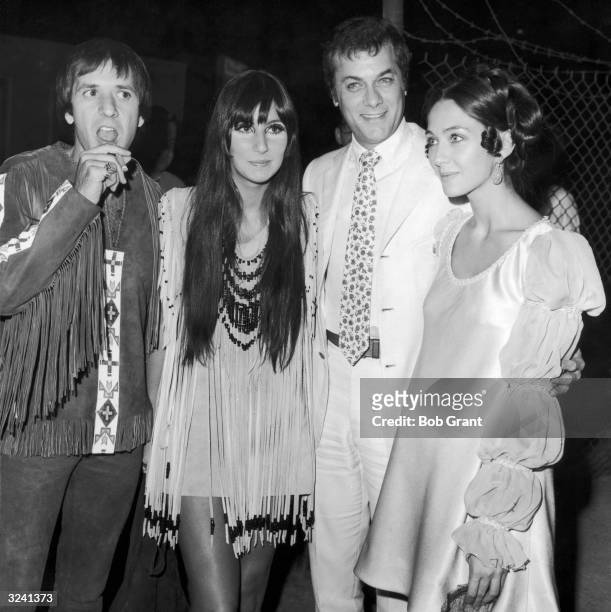 Married American singers Sonny Bono and Cher of the pop duo Sonny and Cher stand with American actor Tony Curtis and his wife, Austrian-born actor...