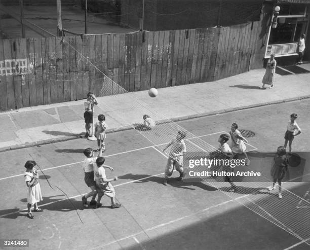 Group of children play volleyball on their makeshift court on Thompson Street in the SoHo neighborhood of New York City.