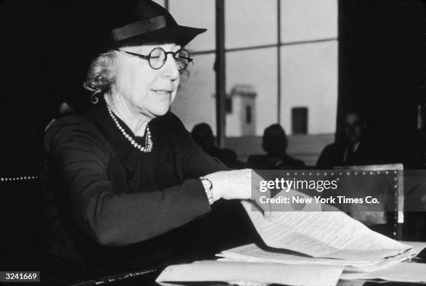 Jeannette Rankin , legislative secretary of the National Council for Prevention of War, leafs through papers as she testifies before the House Naval...