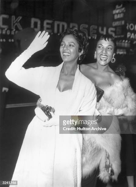 American actors and sisters Dorothy and Vivian Dandridge smile and wave as they arrive at the New York premiere of director Otto Preminger's film,...