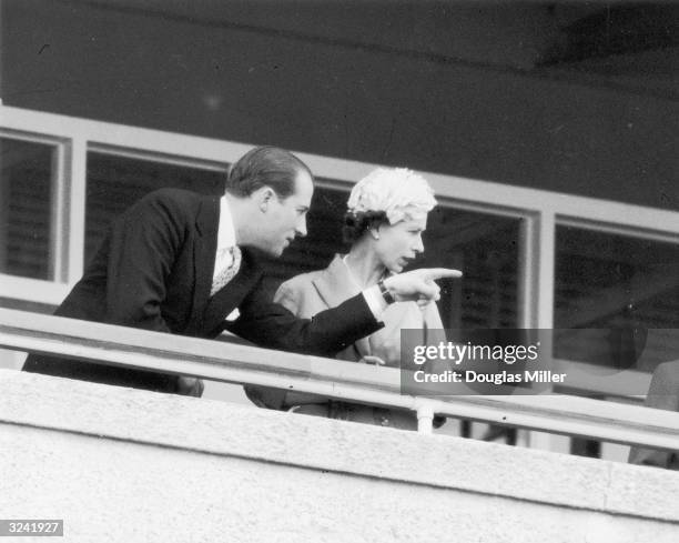 Lord Porchester points out an item of interest to Her MajestyThe Queen, in the Royal Box at Epsom.