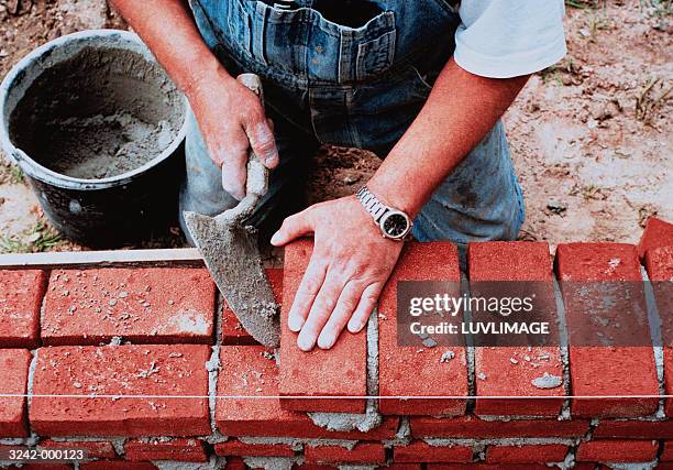 man laying bricks - construction material foto e immagini stock