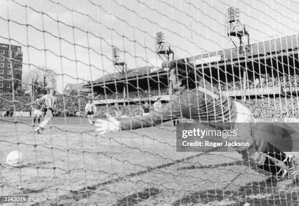 Manchester United goalkeeper Alex Stepney stretches as Southampton's David Peach scores from the penalty spot during a 5th round F A Cup tie.