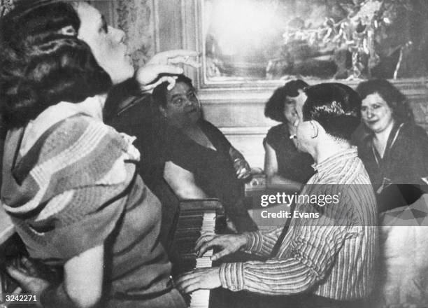 Prostitutes entertaining a German officer in a brothel requisitioned for the use of Nazis.