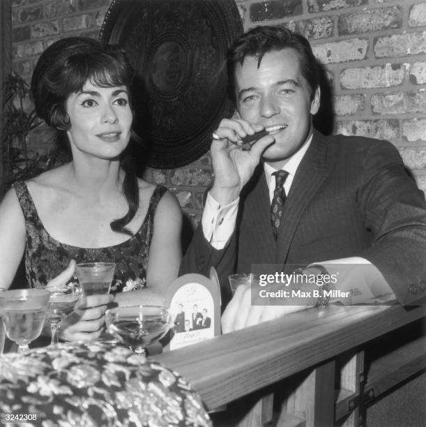 American actor and singer Robert Goulet and his wife, actor and singer Carol Lawrence, sitting at a table at the Vic Damone opening at Century Plaza,...
