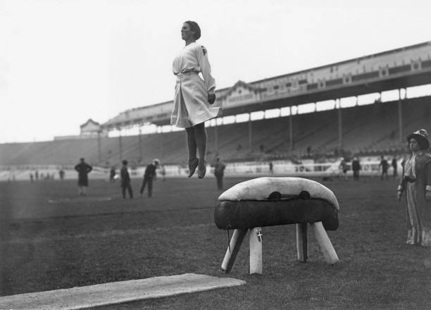 Danish gymnast performing a perfect dismount from a pommel horse during the 1908 London Olympics.