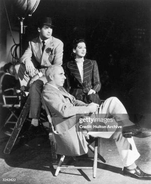 American film director Howard Hawks poses with British-born actor Cary Grant and American actor Rosalind Russell on the set of Hawks' film, 'His Girl...