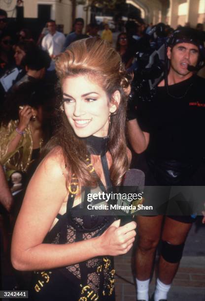 American model Cindy Crawford holds a microphone in front of a cameraman outside the MTV Music Video Awards during her coverage of the event for MTV...