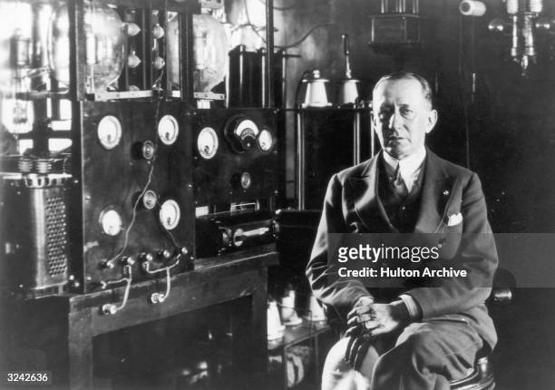 Portrait of the Italian inventor and radio pioneer Guglielmo Marconi sitting in front of a telegraph in the laboratory aboard his yacht 'Electra'.