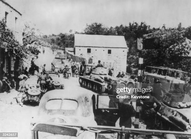 Hotchkiss H-35 and H-39 tanks and motorised Nazi troops crowding a mountain road in Dalmatia, during operations against Yugoslavian partisans. The...