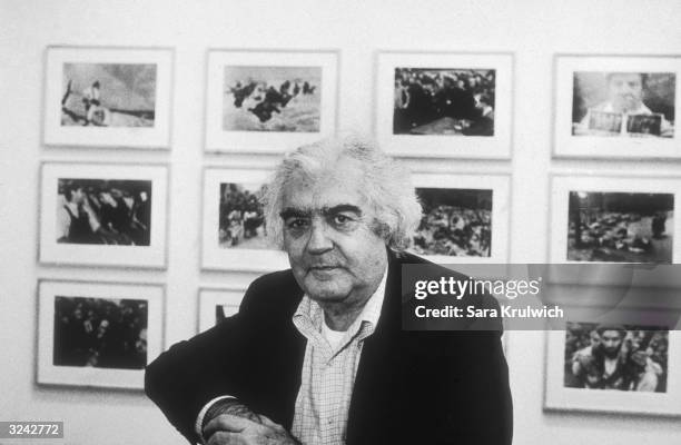 Portrait of Hungarian-born photographer, author and editor Cornell Capa, and brother of photographer Robert Capa, posing in front of a photography...