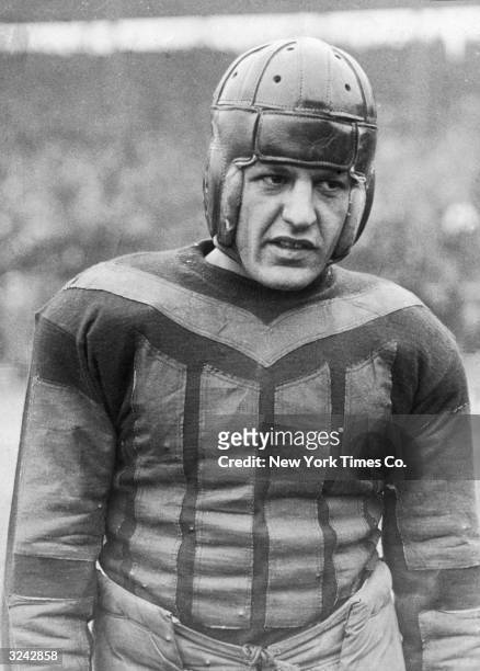 Portrait of the Chicago Bears' football player Harold 'Red' Grange wearing a helmet and football jersey at the start of his first professional game...