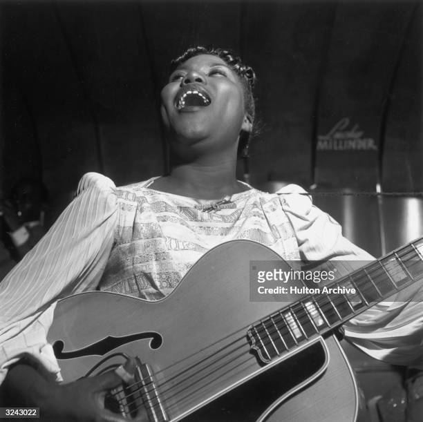 American gospel singer Sister Rosetta Tharpe singing and playing the guitar with the Lucky Millinder Band.