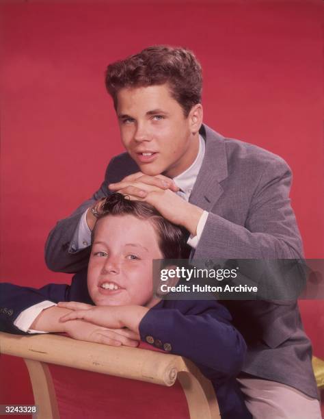 Promotional portrait of American actor Tony Dow as Wally, leaning on American actor Jerry Mathers as his brother Beaver, for the television series...