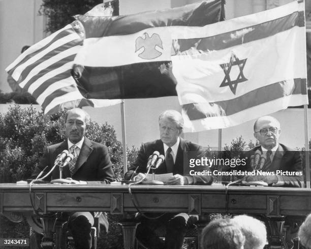 Egyptian president Anwar al-Sadat , United States president Jimmy Carter, and Israeli prime minister Menachem Begin , preparing to sign the Egypt -...