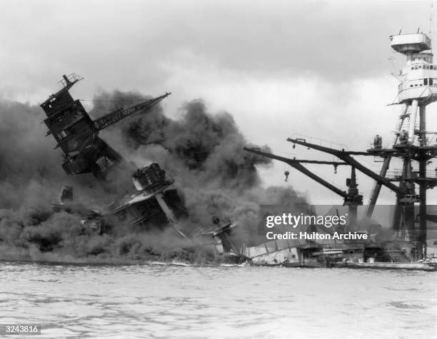 The USS Arizona sinking in a cloud of smoke after the Japanese attack on Pearl Harbor during World War II, Hawaii.