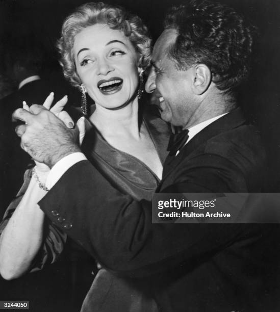 German actor Marlene Dietrich laughs as she dances with Turkish-born film director Elia Kazan at the after-premiere party for director George Cukor's...